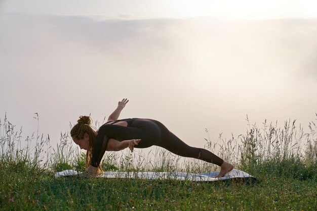 Femme active faisant des exercices de yoga à l'extérieur