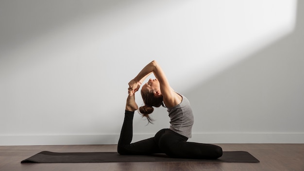 Femme active pratiquant le yoga à la maison