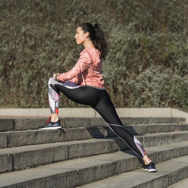 Femme active qui s'étend en plein air