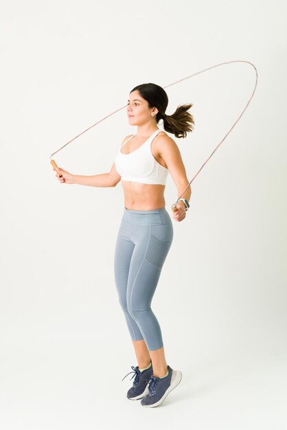 Femme active sautant la corde pendant un HIIT ou un cross-training. Jeune femme avec un mode de vie sain maintenant un corps mince et tonique avec une routine cardio