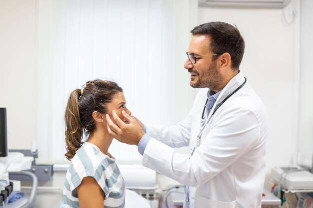 Femme adulte ayant une visite au bureau de l'oculiste Médecin examinant les yeux d'une jeune femme à la clinique