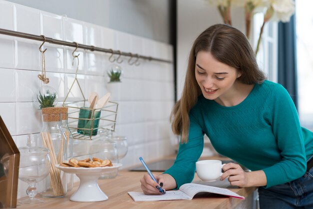 Femme adulte faisant ses devoirs dans la cuisine