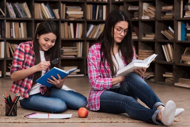 Femme adulte et jeune fille lisant ensemble