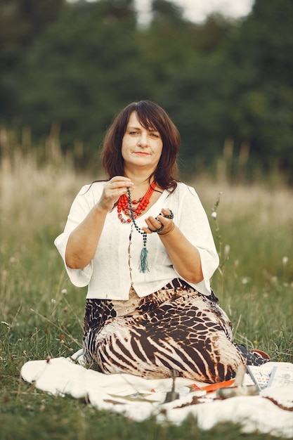 Photo gratuite femme adulte montrant l'outil de méditation sur le pré