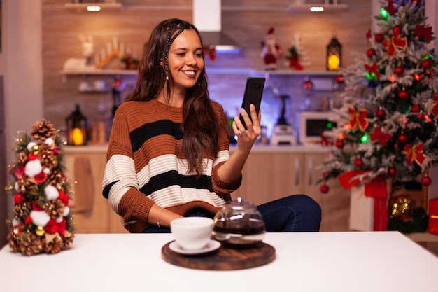 Femme adulte avec smartphone pour visioconférence