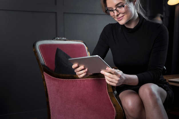 Femme d'affaires adulte vérifiant une tablette