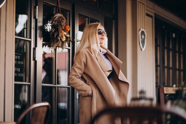 Femme d'affaires âgée dans un manteau à l'extérieur du café