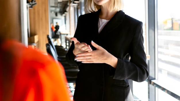 Femme d'affaires à l'aide de la langue des signes au travail