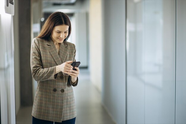 Femme d'affaires à l'aide de téléphone dans un bureau