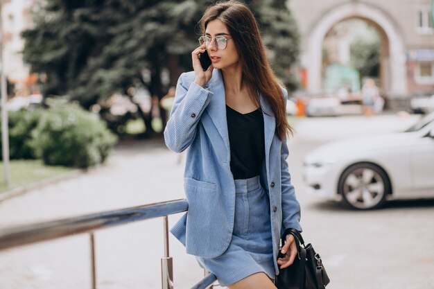 Femme d'affaires à l'aide de téléphone à l'extérieur de la rue