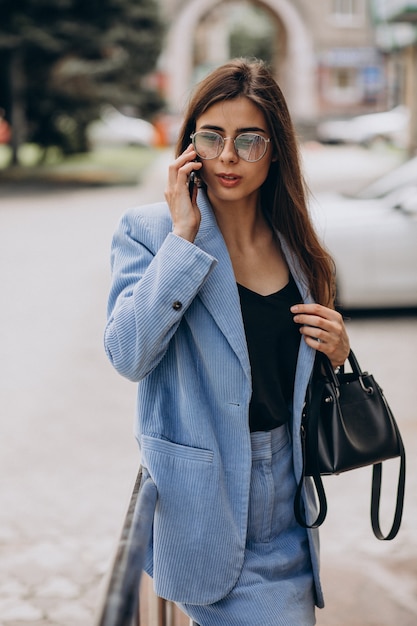 Femme d'affaires à l'aide de téléphone à l'extérieur de la rue