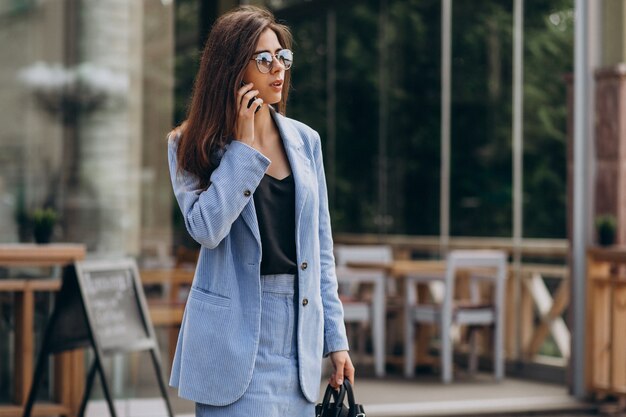 Femme d'affaires à l'aide de téléphone à l'extérieur de la rue