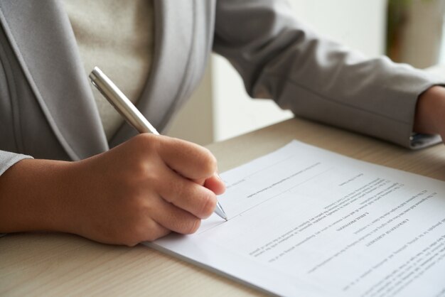 Femme d'affaires anonyme recadrée vérifiant l'accord avant de signer