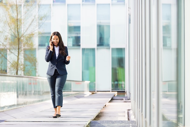 Femme d'affaires asiatique souriante parlant sur smartphone