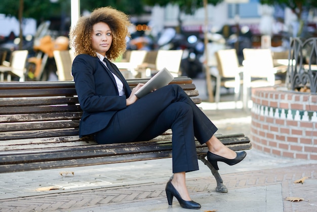 Femme d&#39;affaires assis sur un banc avec une tablette