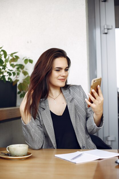 Femme d'affaires assis à la table dans un café et travaillant