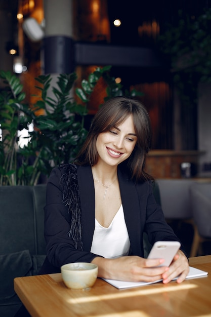 Femme d'affaires assis à la table dans un café et travaillant