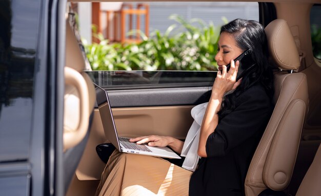 Femme d'affaires assise sur la banquette arrière d'un taxi