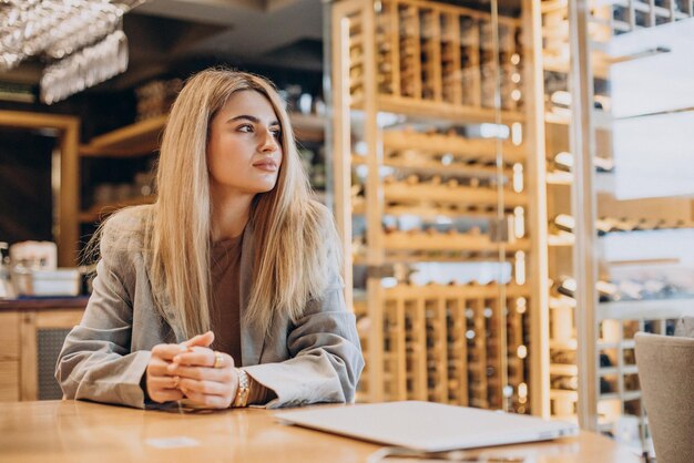 Femme d'affaires assise dans un café et travaillant en ligne