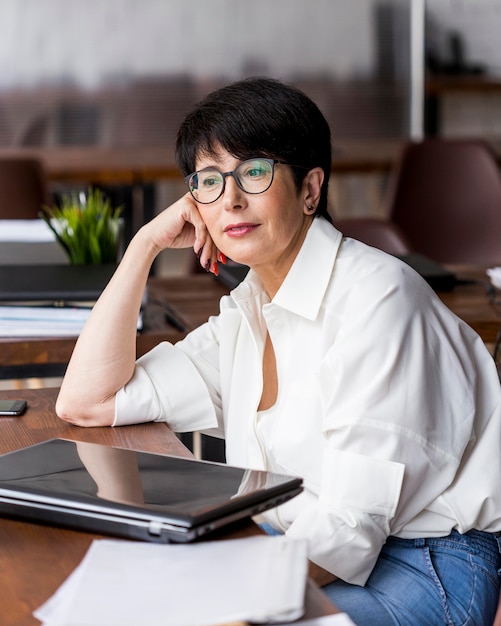 Femme d'affaires aux cheveux courts tenant sa tête avec la main