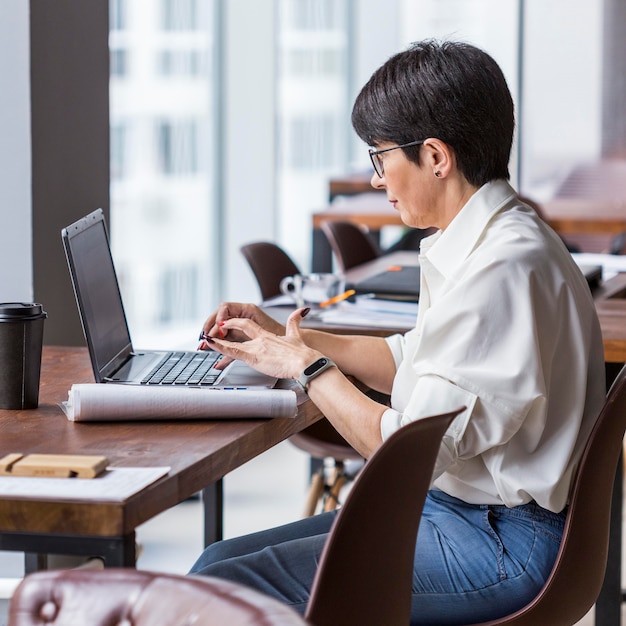 Femme d'affaires aux cheveux courts travaillant à son bureau