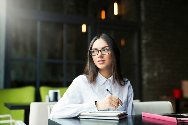 Photo gratuite femme d'affaires avec le bloc-notes au café