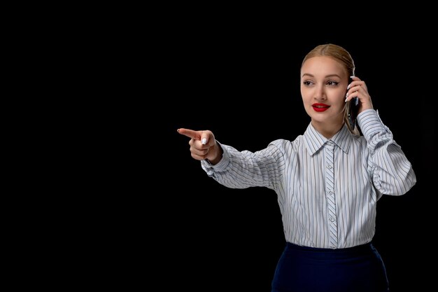 Femme d'affaires blonde jolie dame pointant vers l'avant avec le téléphone avec du rouge à lèvres en costume de bureau