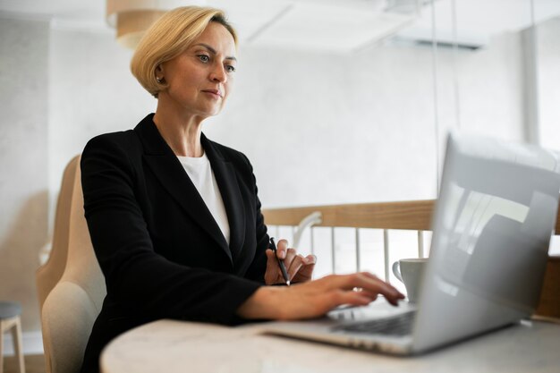 Femme d'affaires blonde travaillant sur son ordinateur portable