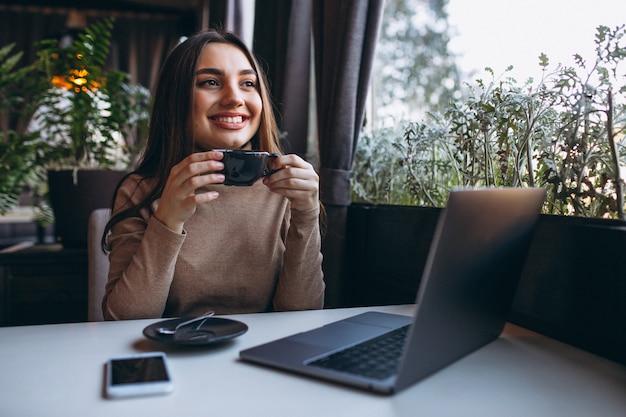 Femme D'affaires, Boire Du Café Et Travaillant Sur Un Ordinateur Portable Dans Un Café