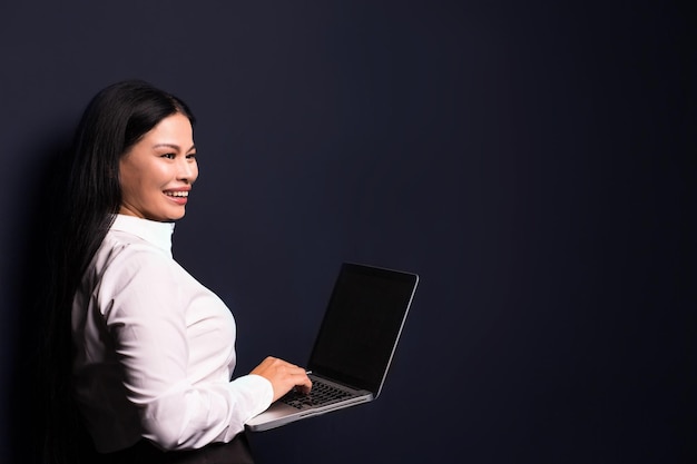femme d'affaires brune tenant un ordinateur portable. Travailler avec des données.