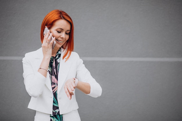 Femme d'affaires chic en costume blanc, parler au téléphone