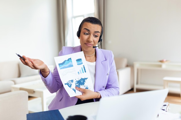 Femme d'affaires ciblée présentant des tableaux et des graphiques lors d'un appel vidéo en ligne Jeune femme d'affaires ayant une conférence téléphonique avec un client sur un ordinateur portable