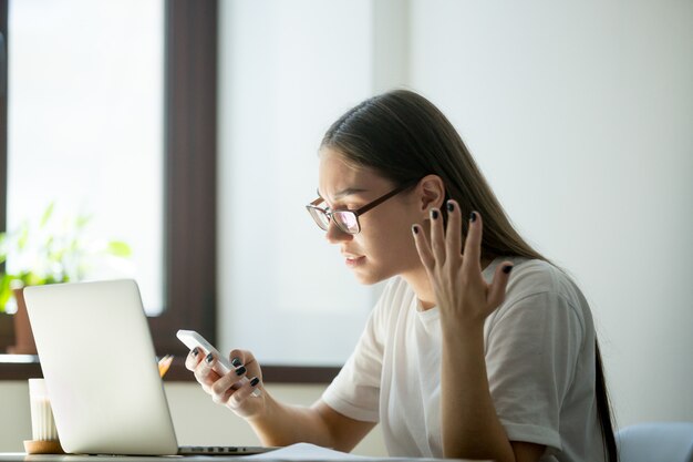 Femme d&#39;affaires confuse en colère ennuyante avec appel téléphonique