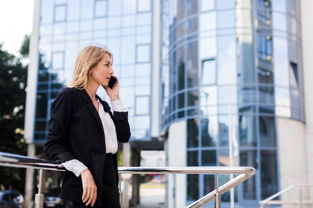 Femme affaires, conversation, téléphone, devant, bâtiment