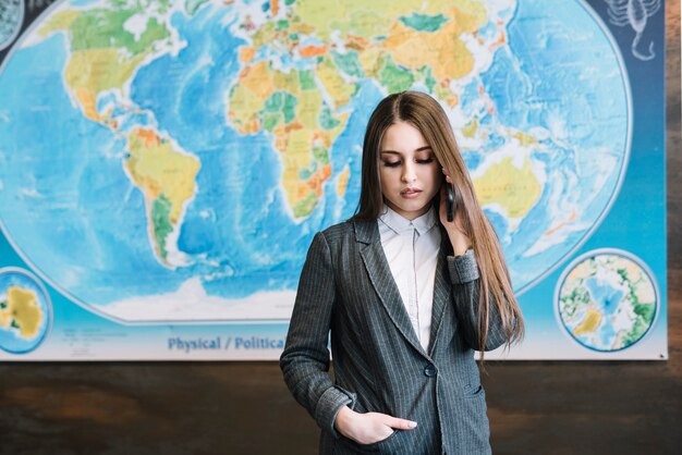 Femme d&#39;affaires en costume parlant par téléphone au bureau