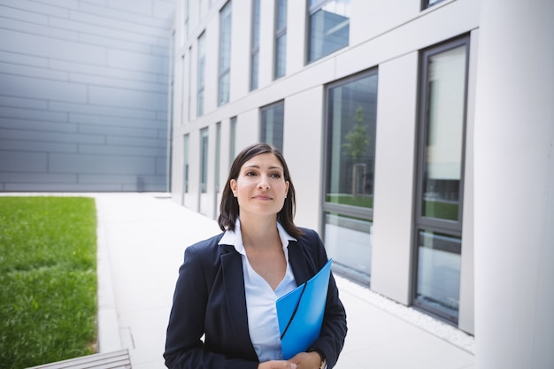 Femme affaires, debout, dehors, immeuble bureaux