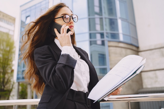 Femme affaires, debout, Dehors, ville, bureau, bâtiment