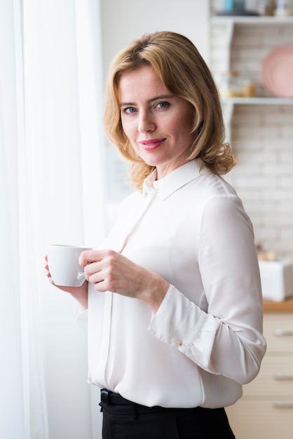 Femme d&#39;affaires debout avec une tasse à café