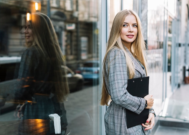 Photo gratuite femme d'affaires élégant avec le presse-papier en ville