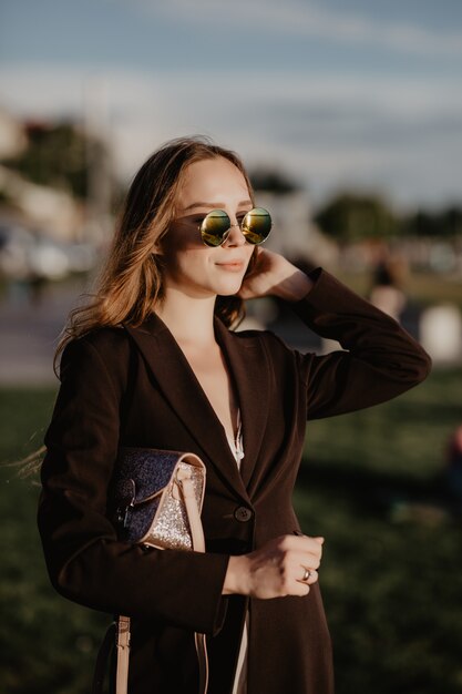 Femme d'affaires élégante portant des lunettes de soleil à la chaude journée d'été dans la ville
