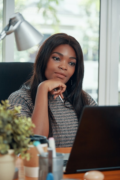 Femme d'affaires ethnique adulte à table de travail