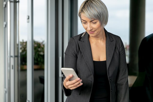 Femme d'affaires à faible angle en regardant téléphone