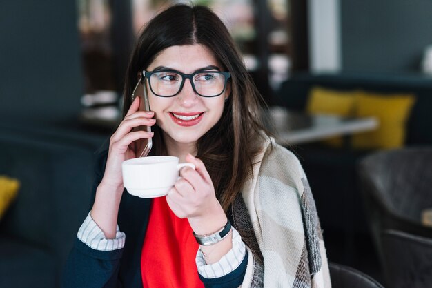 Femme d&#39;affaires faisant un appel téléphonique dans un café