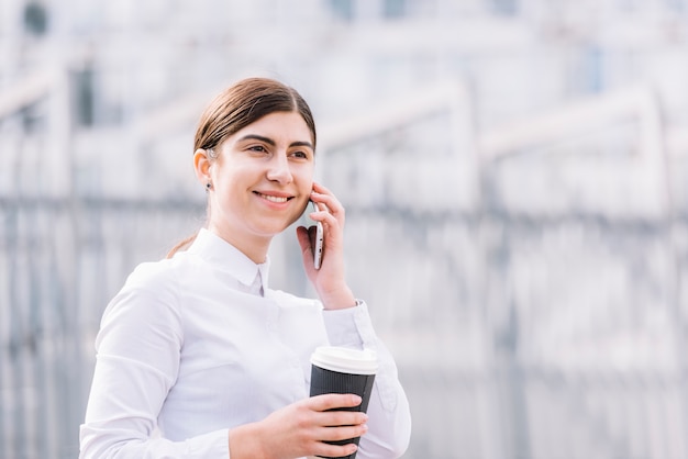 Femme d&#39;affaires faisant un appel téléphonique à l&#39;extérieur