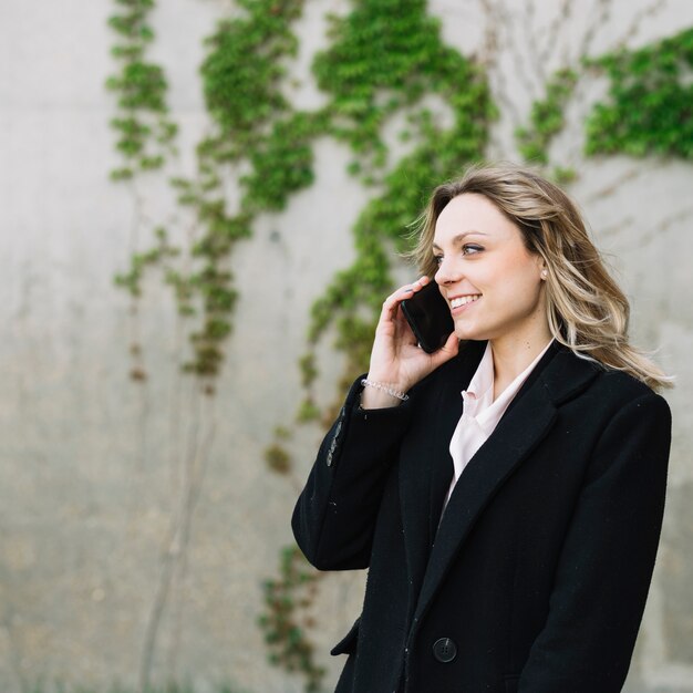 Femme d&#39;affaires faisant un appel téléphonique à l&#39;extérieur