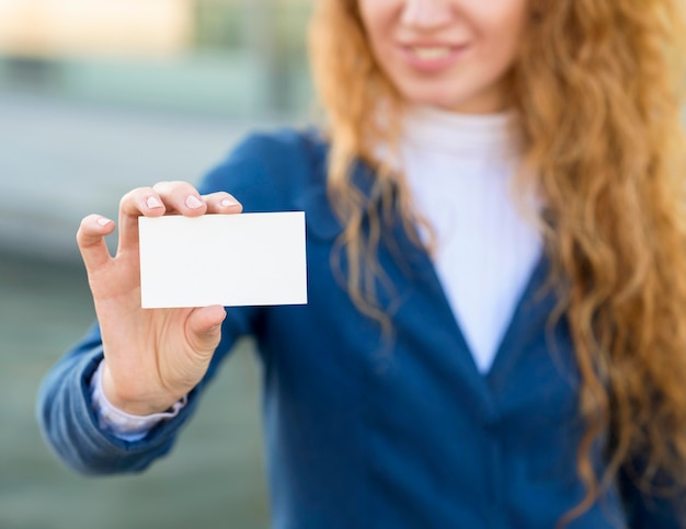 Photo gratuite femme d'affaires floue tenant une carte de visite