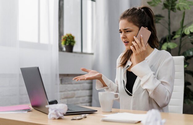 Femme d'affaires à la frustration tout en ayant un appel