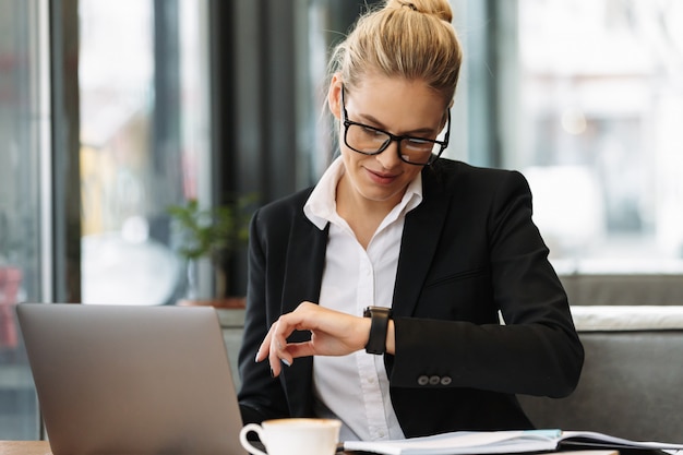 Femme d'affaires gai regardant montre.