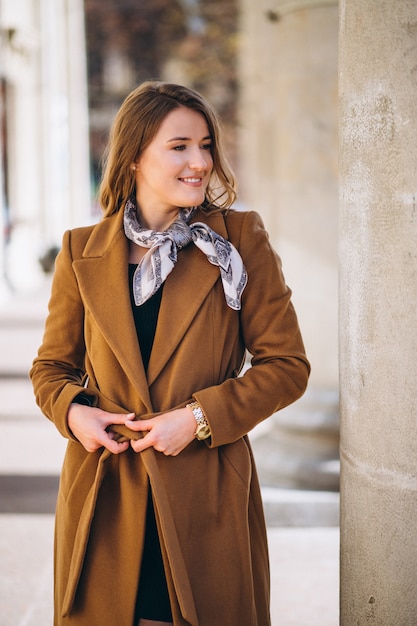 Photo gratuite femme d'affaires heureuse en manteau dans la rue