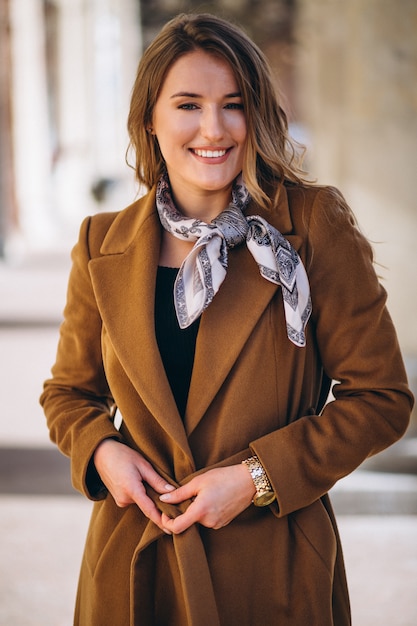 Photo gratuite femme d'affaires heureuse en manteau dans la rue